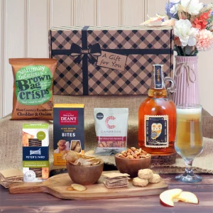 A premium farmhouse cider, gourmet cheese bites, and savory snack gift hamper presentation.