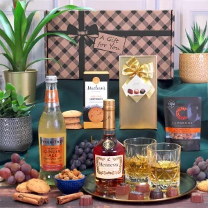 A premium Hennessy cognac, gourmet chocolate, and luxury biscuit gift hamper presentation.