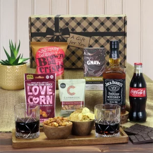 A premium Jack Daniel's whiskey, cola, and savory snack gift hamper presentation.