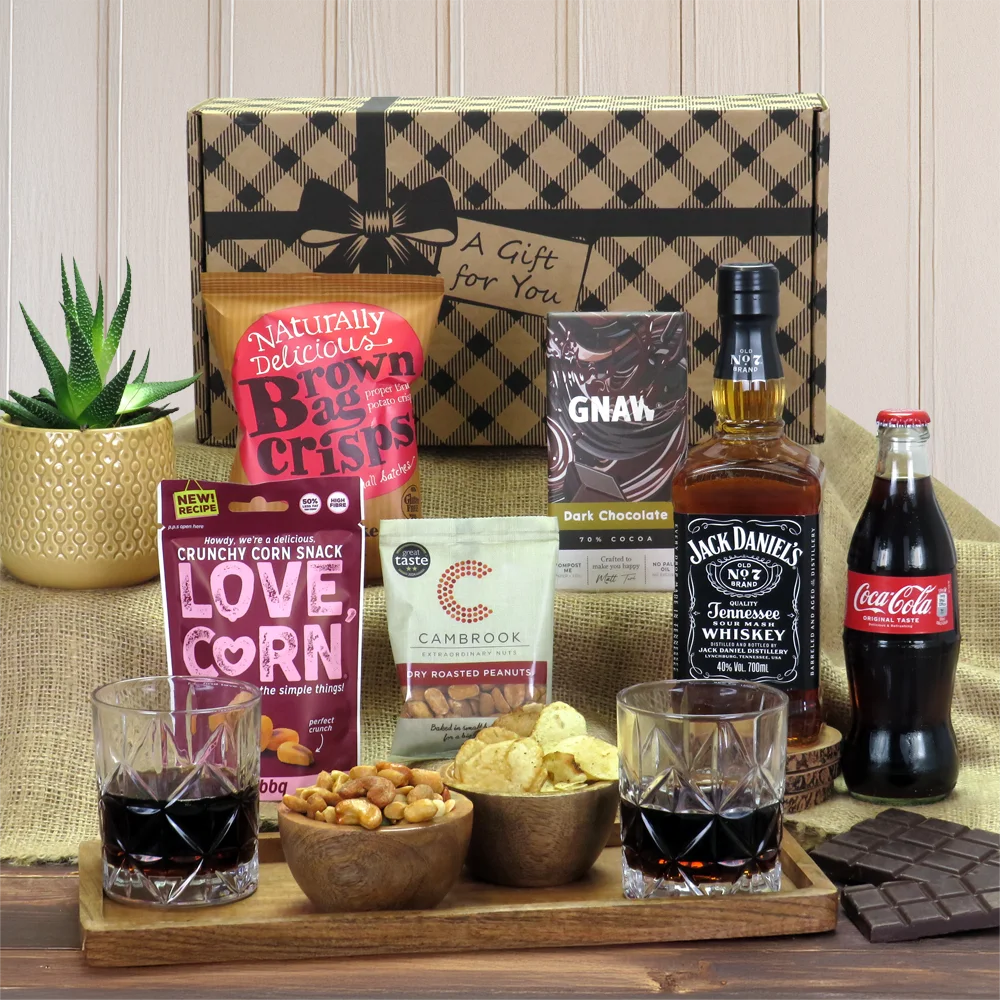 A premium Jack Daniel's whiskey, cola, and savory snack gift hamper presentation.