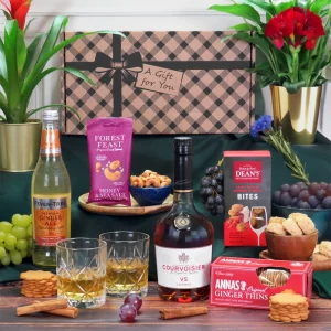 A luxury Courvoisier cognac and gourmet sweet and savory snack hamper presentation.