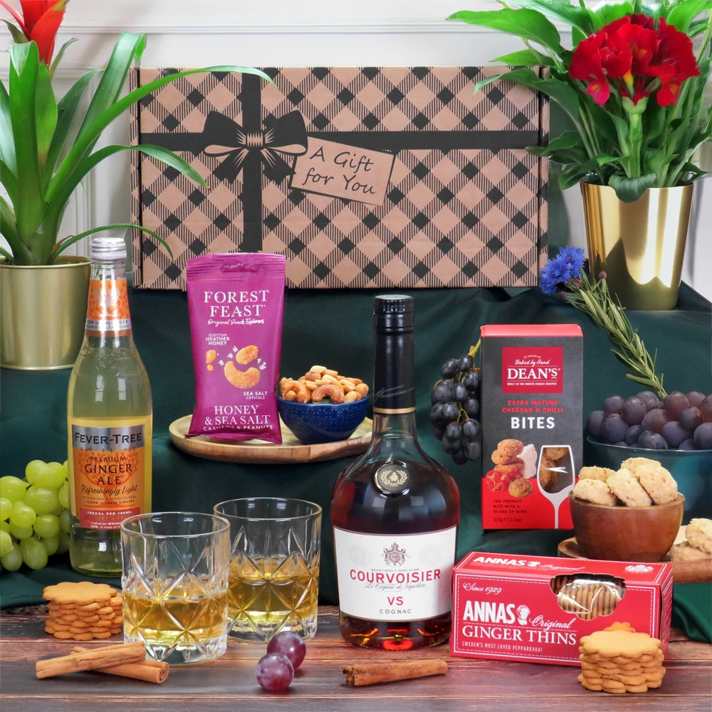 A luxury Courvoisier cognac and gourmet sweet and savory snack hamper presentation.