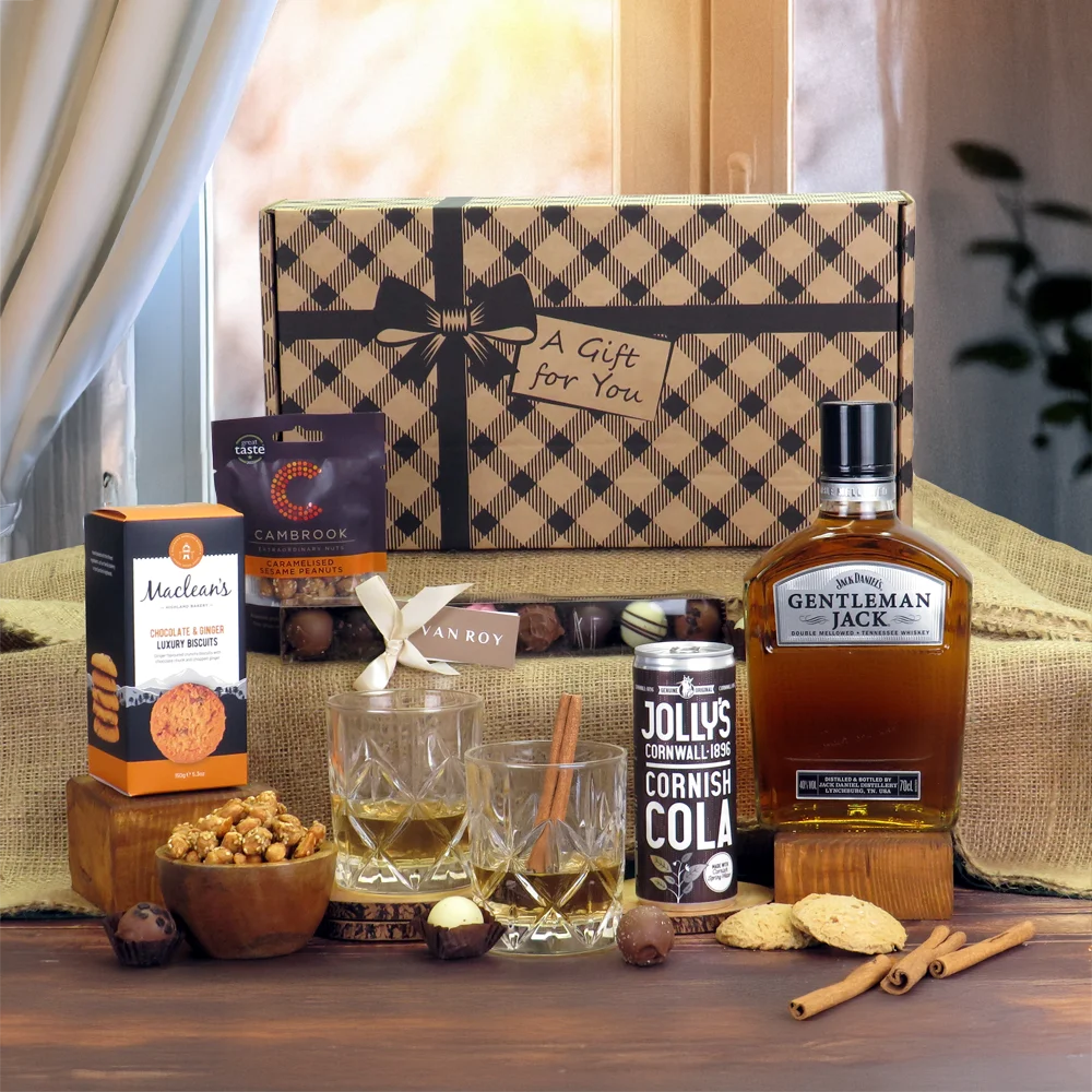 A premium Gentleman Jack whiskey, gourmet chocolate, and luxury biscuit gift hamper presentation.