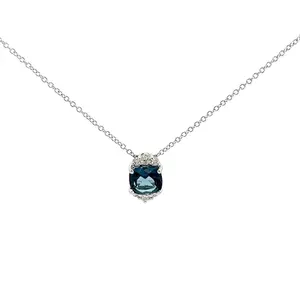 A Natkina Eternelle Necklace featuring an elongated cushion-cut London Blue Topaz pendant set in white gold with diamond accents at the top and bottom.