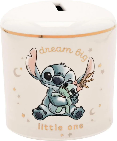 A white ceramic Disney Stitch Magical Beginnings Money Bank with a gold-rimmed top, decorated with a pencil-sketch illustration of baby Stitch holding a Scrump doll.