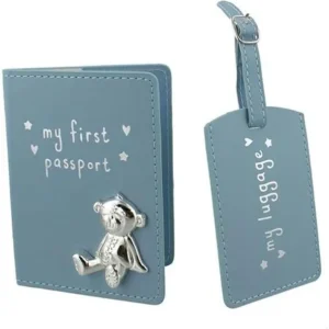 A baby blue faux-leather Button Corner My First Passport & Luggage Tag Set featuring a polished silver teddy bear emblem on the cover.