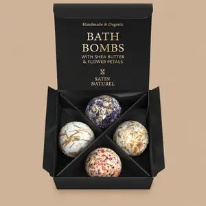 An open black Satin Naturel Bath Bombs Box Set holding four organic, handmade bath balls textured with real flower petals.