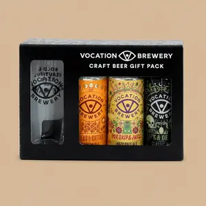 A Vocation Brewery Craft Beer Gift Pack featuring three distinct colorful cans and a branded glass inside a black presentation box.