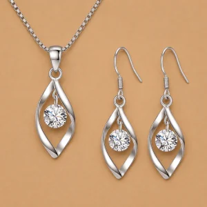 925 sterling silver jewelry set featuring an infinity-style twisted ribbon pendant necklace and matching drop earrings. Each piece holds a sparkling round clear crystal in the center of the silver silhouette.