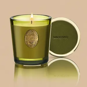 An "M&SENSE" luxury olive-green jar candle with a decorative gold emblem and lid.