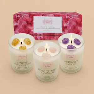 An ORCHID AURA three-piece crystal-infused soy wax candle gift set with Citrine, Rose Quartz, and Amethyst stones.