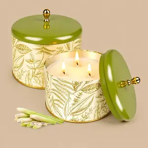 A three-wick lemongrass scented candle in a gold and green botanical metal tin with lid.