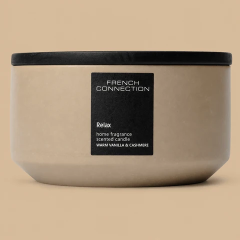 A wide French Connection Relax Warm Vanilla & Cashmere ceramic bowl candle with a black lid.