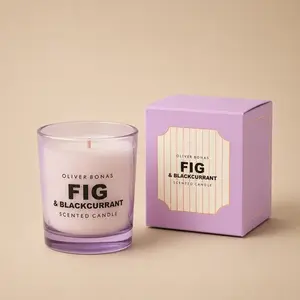 An Oliver Bonas Fig & Blackcurrant jar candle next to its purple box.