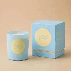 An Oliver Bonas A Moment of Calm blue jar candle next to its product box.