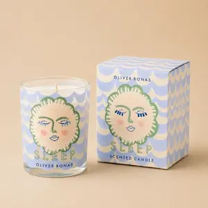 An Oliver Bonas Sleep jar candle with illustrated waves next to its product box.