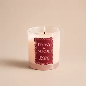 A lit Bloom & Wild Peony & Neroli pink jar candle.
