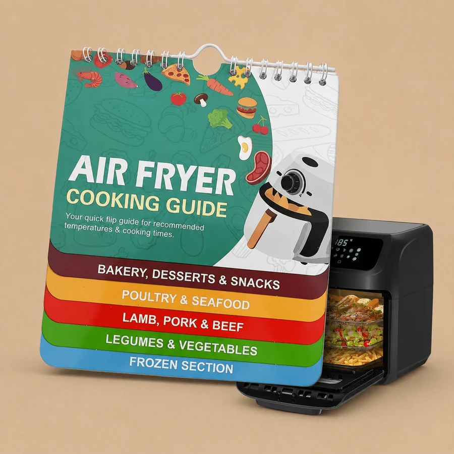 A tiered, spiral-bound air fryer cooking guide flip chart with colorful index tabs for food categories, placed next to a modern black air fryer oven on a neutral beige background.