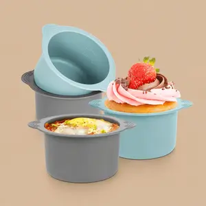 Reusable silicone air fryer baking molds in blue and grey. The set shows a cup displaying internal volume measurements alongside finished examples containing a frosted cupcake and a baked egg frittata.