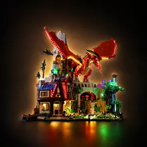 A completed LEGO Ideas Dungeons & Dragons: Red Dragon's Tale set fully illuminated with a custom LED lighting kit, highlighting a massive red dragon perched on a medieval tower ruins above a glowing tavern.