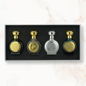 "An open rectangular fragrance gift box featuring four miniature, rounded Boadicea the Victorious perfume bottles in dark green, clear glass with a gold monkey emblem, metallic silver, and deep dark blue, each showcasing detailed circular shields."