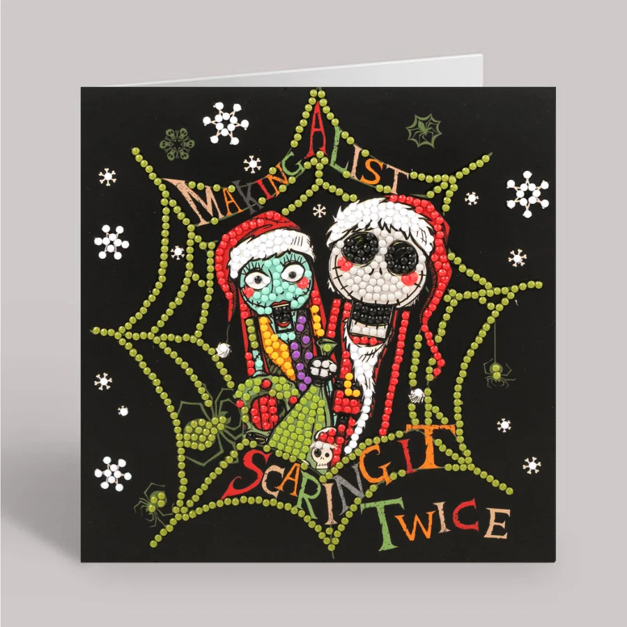 A completed Disney Crystal Art Christmas card showing diamond-painted Jack and Sally nutcracker figures on a black background decorated with white snowflakes.