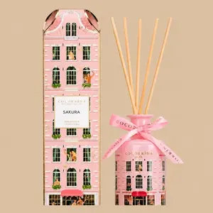 A Cocorrína Sakura reed diffuser set featuring a pink building-shaped gift box and matching ceramic diffuser bottle with a pink ribbon.