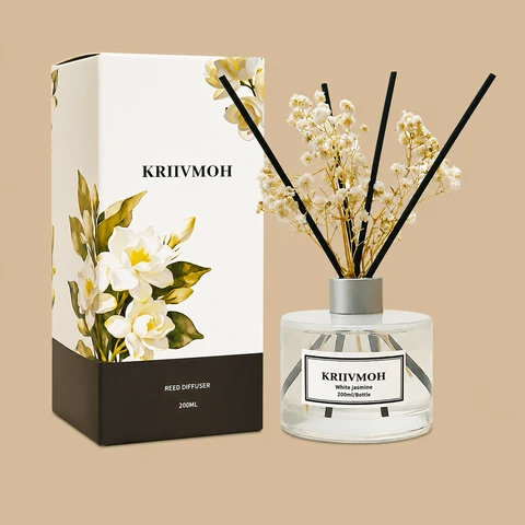 A KRIIVMOH White Jasmine reed diffuser set featuring a clear glass bottle styled with black reeds, dried baby's breath, and a floral-illustrated gift box.