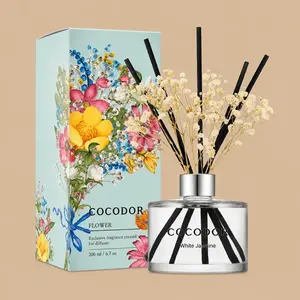 A Cocodor White Jasmine reed diffuser set featuring a clear glass bottle styled with black reeds, dried baby's breath, and a vibrant, flower-illustrated gift box.