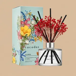 A Cocodor Black Cherry reed diffuser set featuring a clear glass bottle styled with black reeds, vibrant red baby's breath, and a colorful floral gift box.