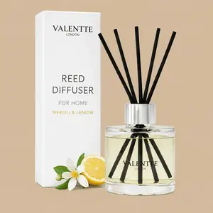 A Valentte London Neroli & Lemon reed diffuser set featuring a clear glass bottle with black sticks alongside a minimalist white gift box.