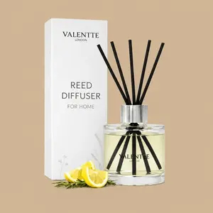A Valentte London Mandarin & Grapefruit reed diffuser set featuring a clear glass bottle with six black sticks next to its minimalist white gift box.