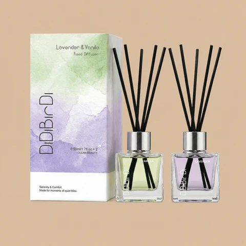 A DiDiBirDi Lavender & Vanilla reed diffuser set featuring a watercolor-styled gift box alongside two clear glass diffuser bottles with black reeds.