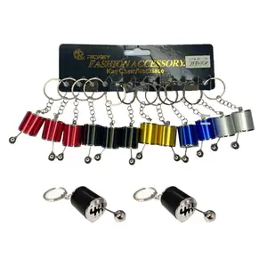 A multi-pack retail card of colorful 6-speed manual gear shifter keychains with two loose black variants displayed below.