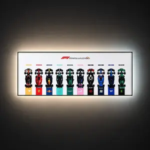 A horizontal, wall-mounted Brick Zone Hub White F1 10-Car Display Frame featuring an official red and black "#WeRaceAsOne" logo banner and ten brick-built race cars lined up side-by-side with bright white integrated ambient backlighting