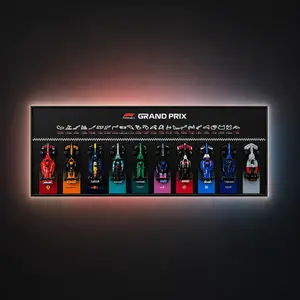 A horizontal, wall-mounted LEGO Speed Champions F1 Grand Prix display frame featuring ten brick-built race cars lined up beneath a row of minimalist circuit silhouettes and an ambient-lit orange background glow.