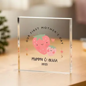 A thick, square-shaped clear acrylic block keepsake featuring an illustration of two smiling cartoon strawberries and the text "Our First Mother's Day, Mummy & Olivia 2025".