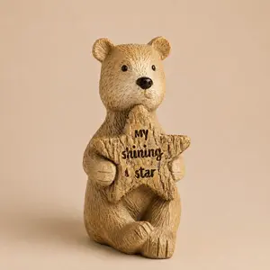 A small, textured tan bear figurine holding a star that reads "My shining star."