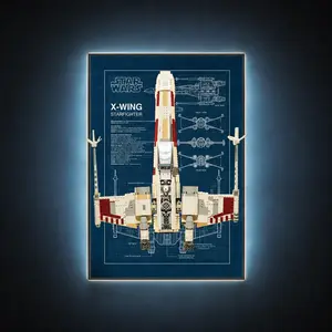A completed LEGO Star Wars UCS X-Wing Starfighter mounted vertically inside a backlit wall frame featuring a classic blue blueprint schematic design.