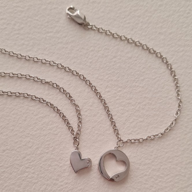 "A matching pair of 925 sterling silver chain bracelets from Hot Diamonds, featuring one bracelet with a small solid heart charm and the other with an open, circular heart-cutout charm, both accented with a single round-cut diamond."