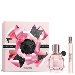 Viktor & Rolf Flowerbomb fragrance set featuring a pink gift box adorned with an oversized 3D satin bow graphic and black wax seal, a faceted grenade-style perfume bottle, and a slim travel spray.
