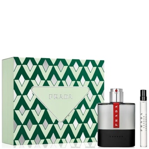 Prada Luna Rossa Carbon gift set featuring a green geometric triangle patterned box, a charcoal and black cologne bottle with a prominent red logo stripe, and a slim travel spray vial.