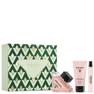 Prada Paradoxe women's gift set featuring a green and gold chevron-patterned box, a triangular pink perfume bottle, a matching pink tube of body lotion, and a slim travel spray vial.